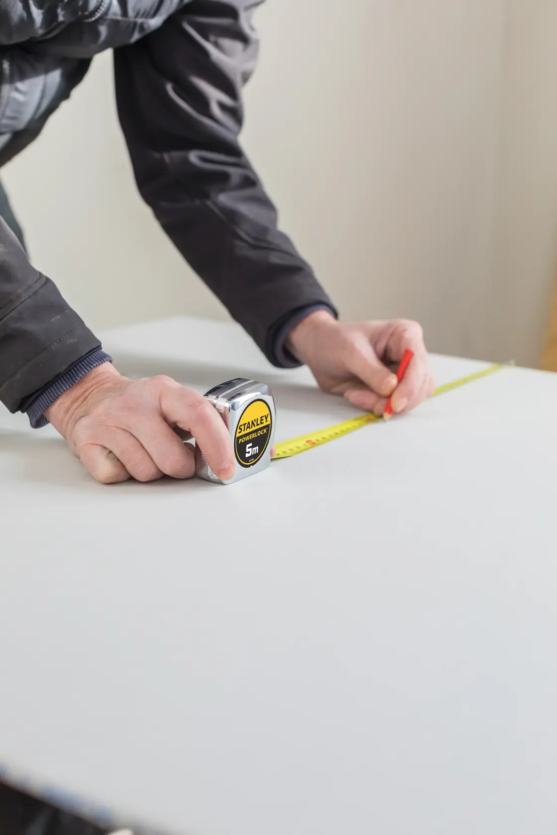 STANLEY 0-33-194 tape measure used to mark a measurement on a white board, close-up.