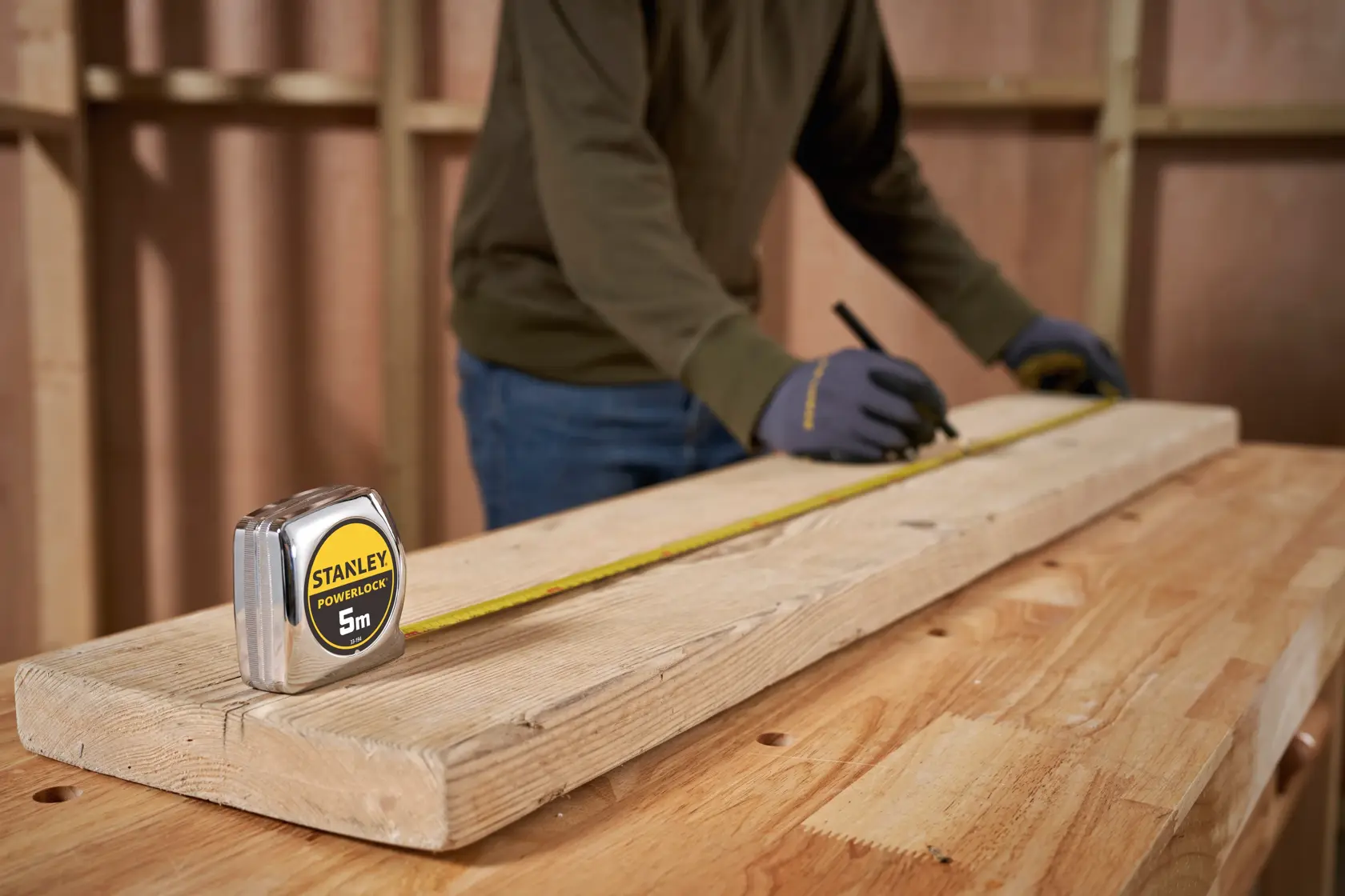 STANLEY 1-33-194 tape measure in use on wooden plank, photo of product in carpentry setting.