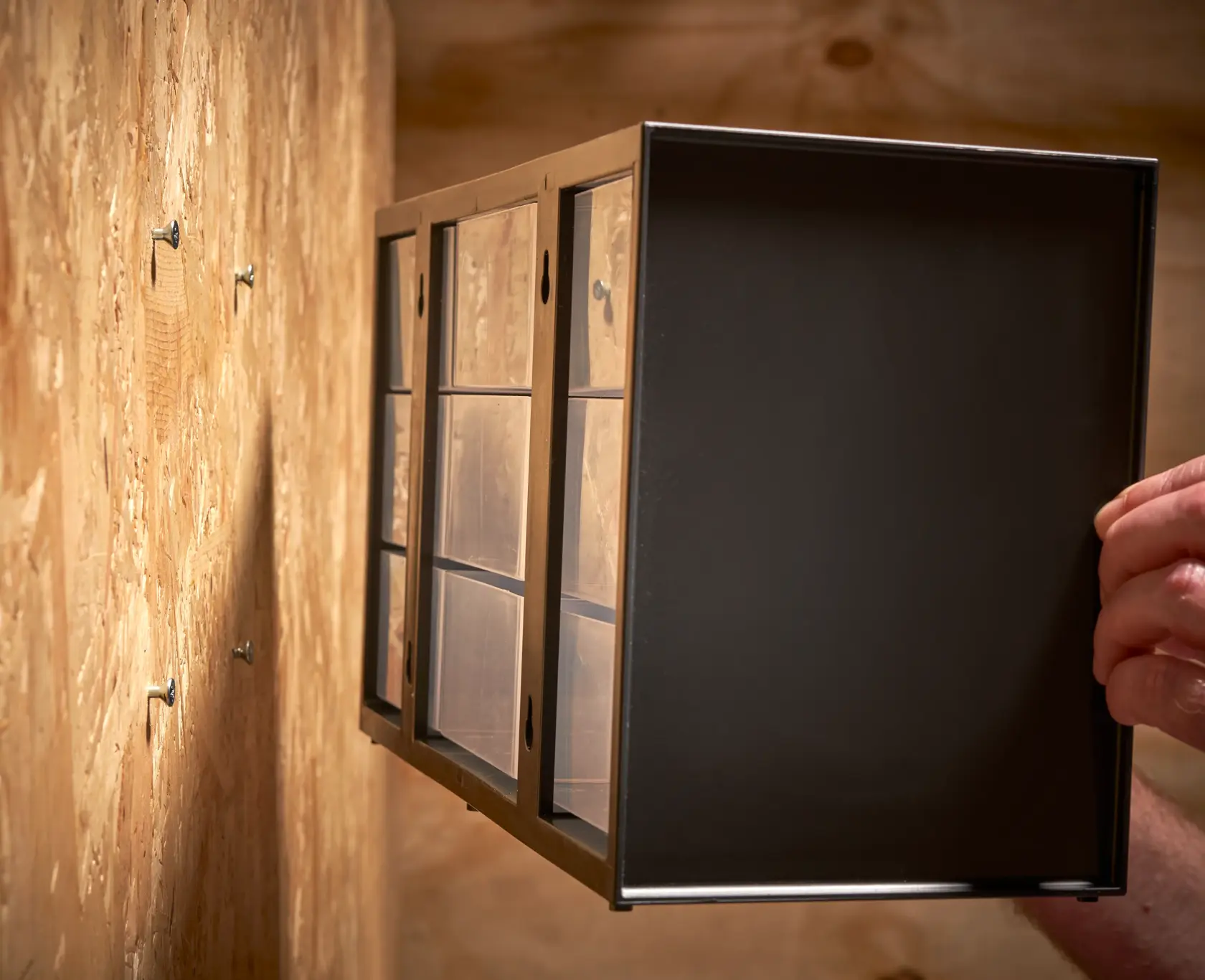 STANLEY 1-93-978 storage drawer cabinet being mounted on a wooden wall, angled side view.