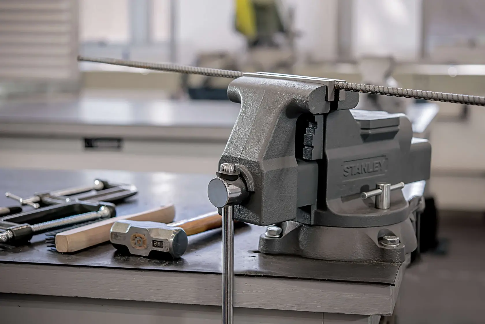 STANLEY bench vise 83-066, 1-83-066 mounted on workbench, with tools and metal rod, side angle photography.