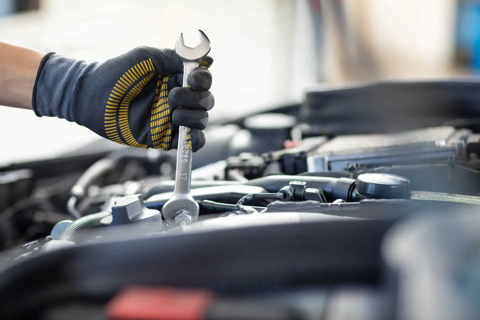 STANLEY FMMT13065-0 spanner used on car engine by gloved hand, close-up, product in use.