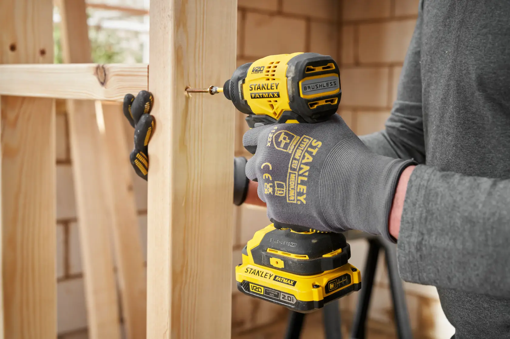 STANLEY SFMCF811D1T impact driver in use driving a screw into wood, close-up side view.
