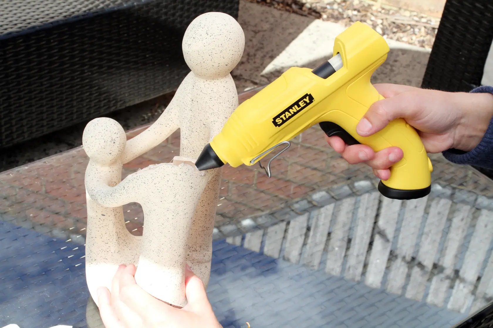 STANLEY STHT6-70416 yellow glue gun used to repair stone sculpture, side angle, photography product.