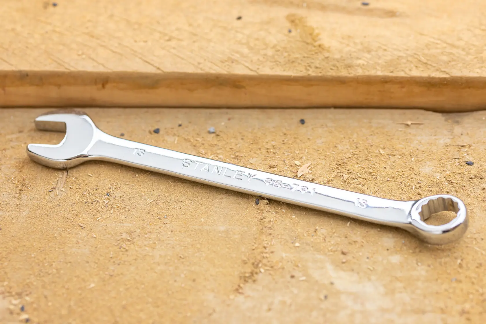 STANLEY STMT95790-0 combination wrench, silver finish, angled view, placed on wood surface.