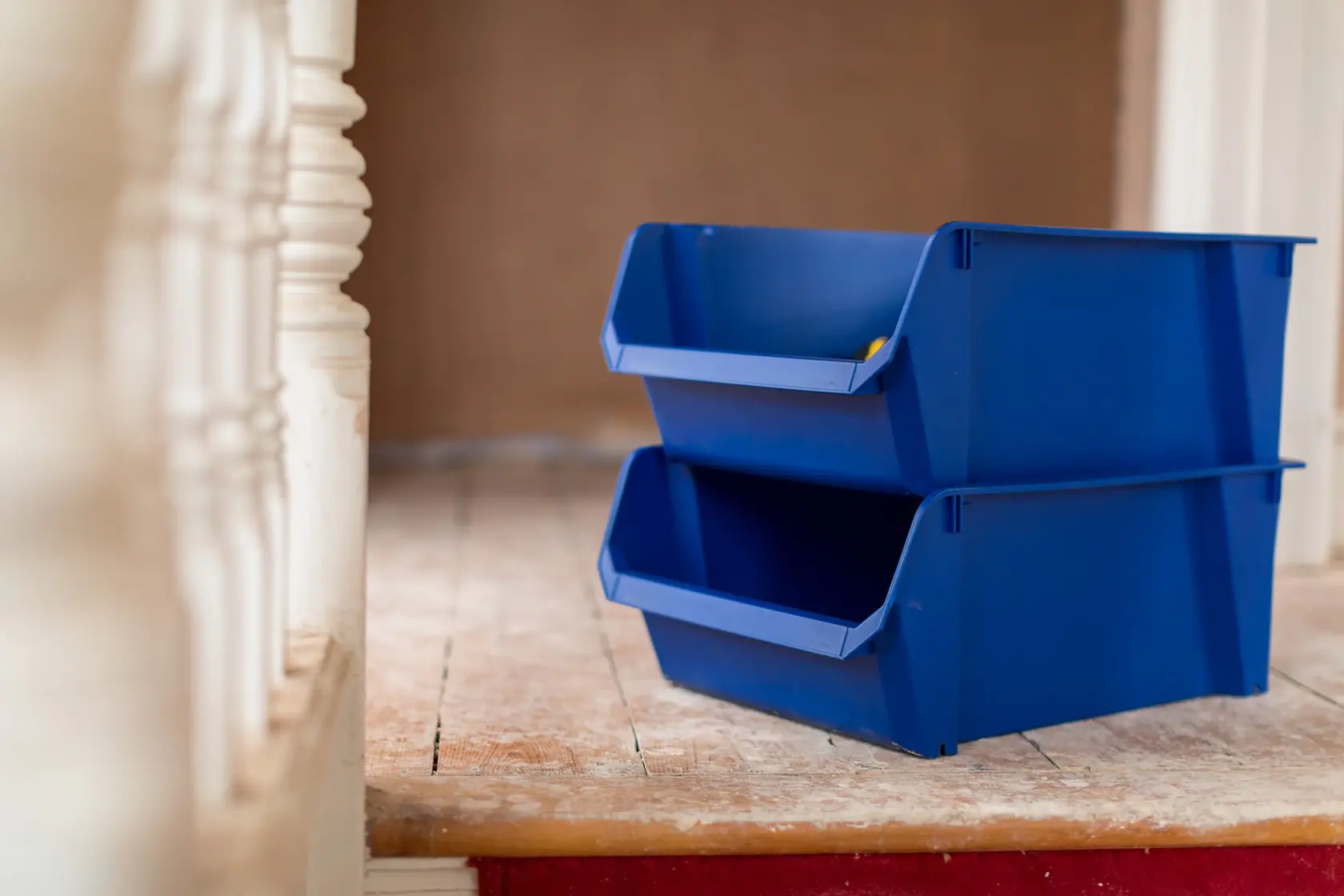 STANLEY STST82746-1 blue stackable storage bins, photo of two bins on wooden floor, side angle.