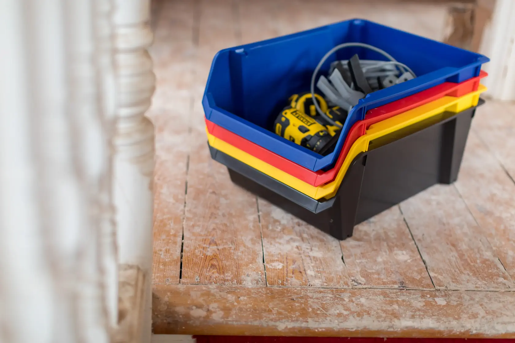 STANLEY STST82746-1 stackable storage bins in blue, red, yellow, and black holding tools, photographed indoors.
